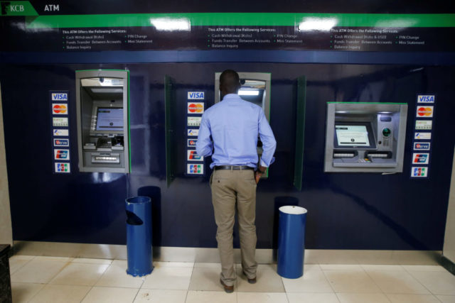 A customer uses an ATM outside the banking hall at the Kenya Commercial Bank, Kipande house branch in Nairobi
